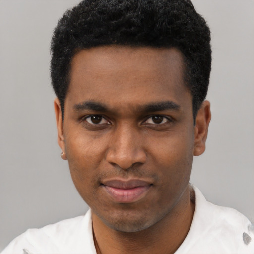 Joyful black young-adult male with short  black hair and brown eyes