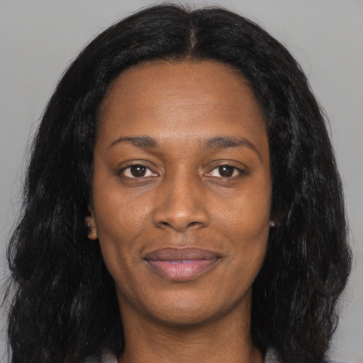 Joyful black young-adult female with long  black hair and brown eyes
