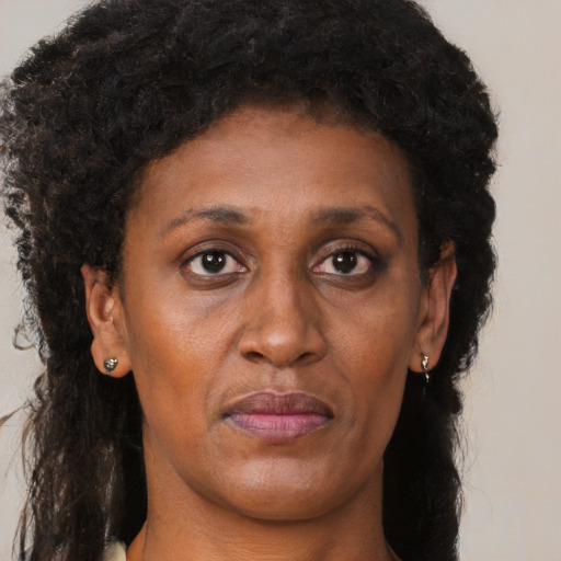 Joyful black adult female with long  brown hair and brown eyes