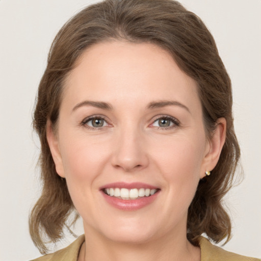 Joyful white young-adult female with medium  brown hair and green eyes