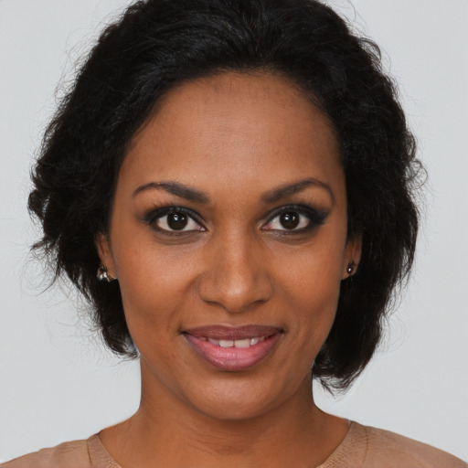 Joyful black adult female with long  brown hair and brown eyes
