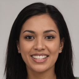 Joyful latino young-adult female with long  brown hair and brown eyes