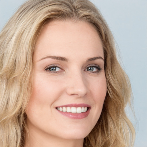 Joyful white young-adult female with long  brown hair and blue eyes