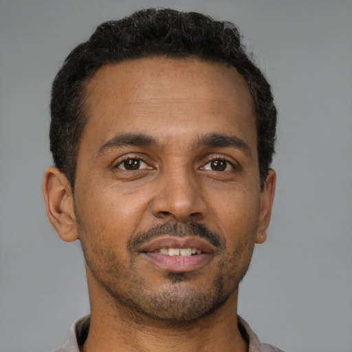 Joyful latino adult male with short  brown hair and brown eyes