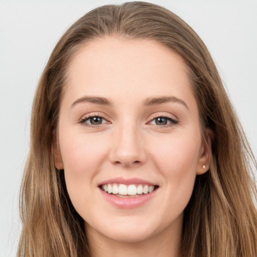 Joyful white young-adult female with long  brown hair and grey eyes