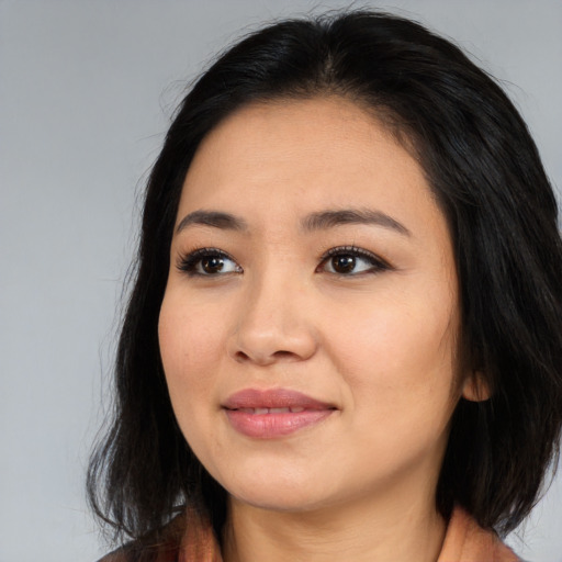 Joyful asian young-adult female with long  black hair and brown eyes