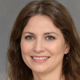 Joyful white adult female with long  brown hair and brown eyes