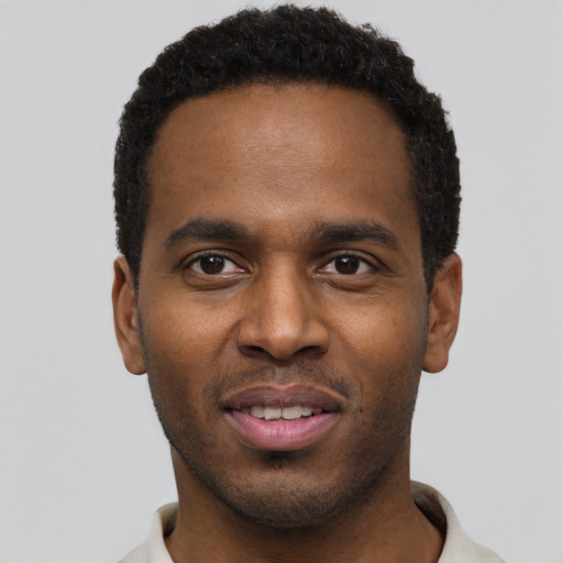 Joyful black young-adult male with short  black hair and brown eyes