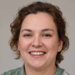 Joyful white adult female with medium  brown hair and green eyes