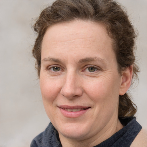 Joyful white adult female with medium  brown hair and blue eyes