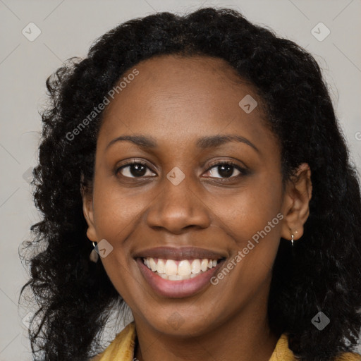 Joyful black young-adult female with long  brown hair and brown eyes