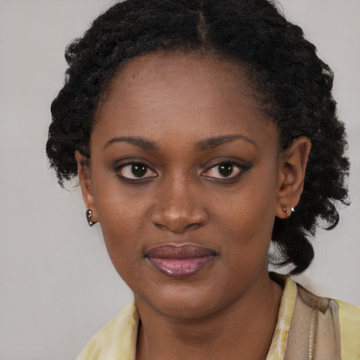 Joyful black young-adult female with long  brown hair and brown eyes