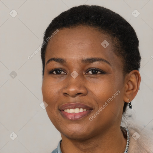 Joyful black young-adult female with short  black hair and brown eyes