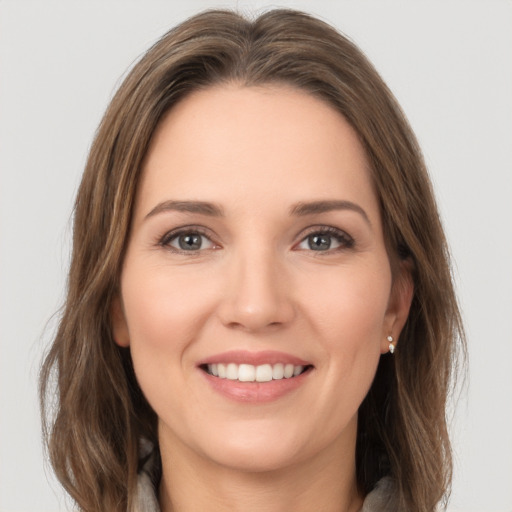 Joyful white young-adult female with long  brown hair and grey eyes