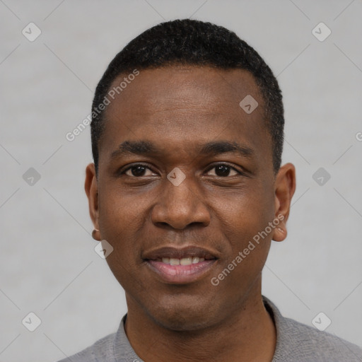 Joyful black young-adult male with short  black hair and brown eyes