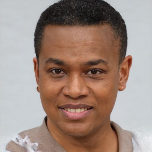 Joyful black young-adult male with short  brown hair and brown eyes