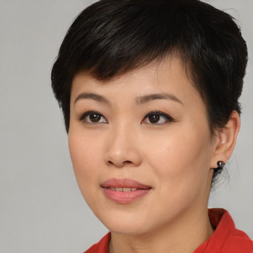 Joyful asian young-adult female with short  brown hair and brown eyes