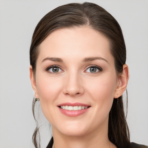 Joyful white young-adult female with long  brown hair and grey eyes