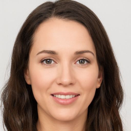 Joyful white young-adult female with long  brown hair and brown eyes