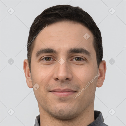 Joyful white young-adult male with short  black hair and brown eyes