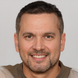 Joyful white adult male with short  brown hair and brown eyes