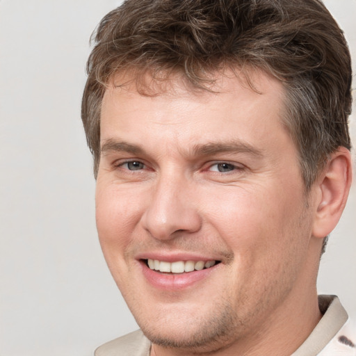 Joyful white adult male with short  brown hair and brown eyes