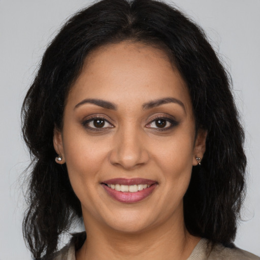 Joyful latino young-adult female with long  brown hair and brown eyes