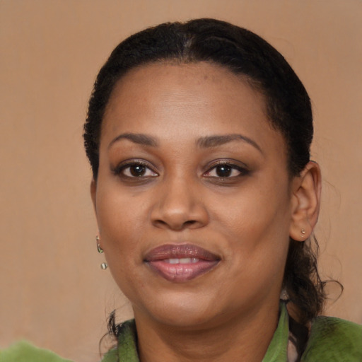 Joyful black adult female with long  brown hair and brown eyes