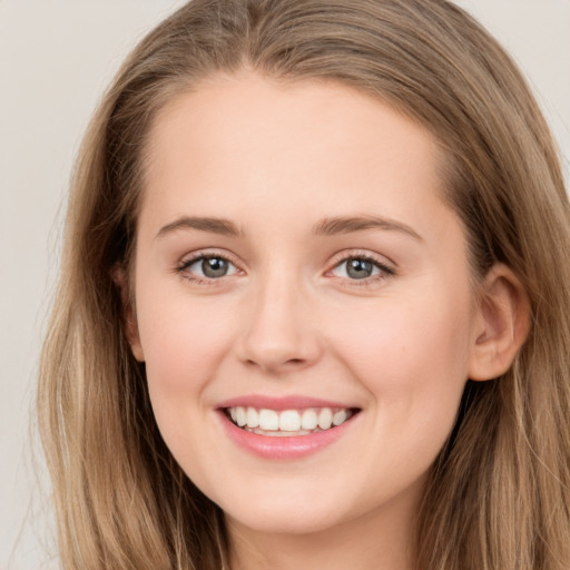 Joyful white young-adult female with long  brown hair and grey eyes