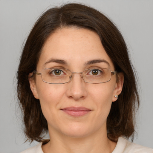 Joyful white adult female with medium  brown hair and green eyes