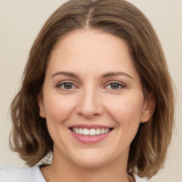 Joyful white young-adult female with medium  brown hair and green eyes