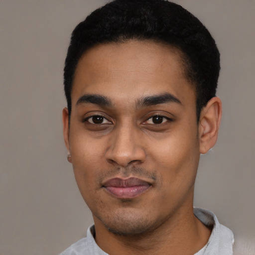 Joyful black young-adult male with short  black hair and brown eyes