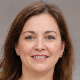 Joyful white adult female with long  brown hair and grey eyes