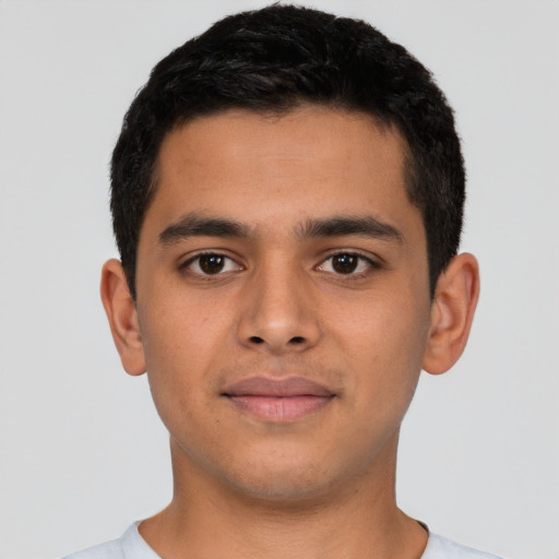 Joyful latino young-adult male with short  brown hair and brown eyes