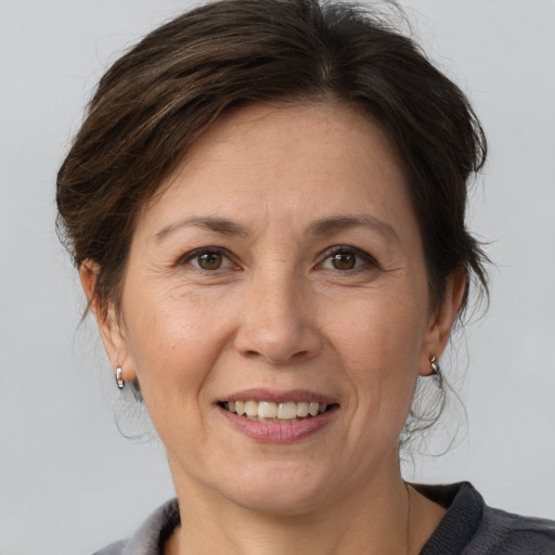 Joyful white adult female with medium  brown hair and grey eyes