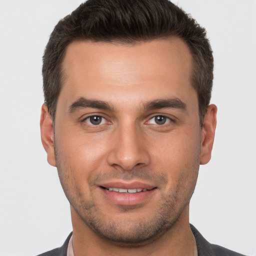 Joyful white young-adult male with short  brown hair and brown eyes