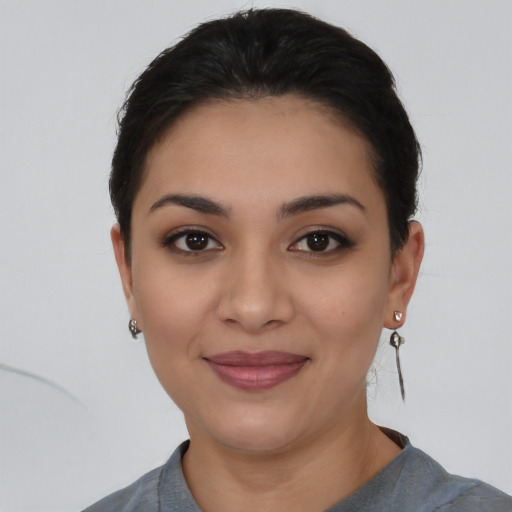 Joyful latino young-adult female with short  black hair and brown eyes