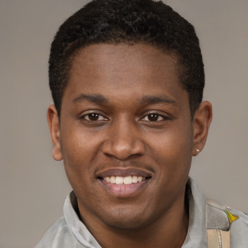 Joyful black young-adult male with short  brown hair and brown eyes