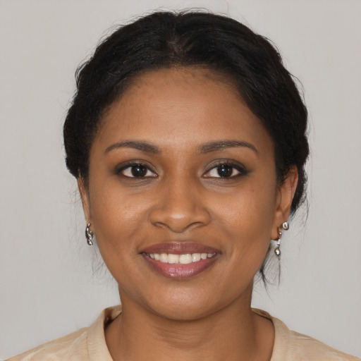 Joyful black young-adult female with medium  brown hair and brown eyes