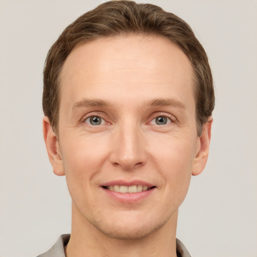 Joyful white adult male with short  brown hair and grey eyes