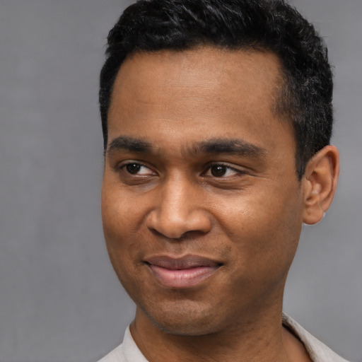 Joyful latino young-adult male with short  black hair and brown eyes