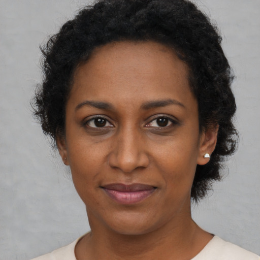 Joyful black adult female with short  brown hair and brown eyes
