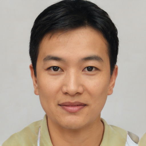 Joyful asian young-adult male with short  black hair and brown eyes