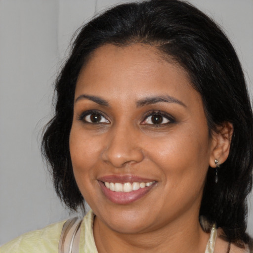 Joyful black young-adult female with medium  brown hair and brown eyes