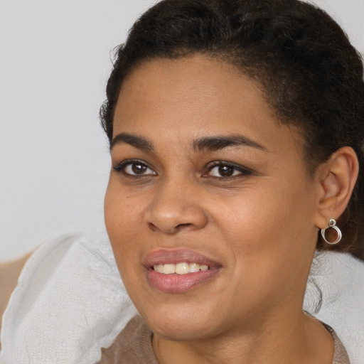 Joyful black young-adult female with short  brown hair and brown eyes