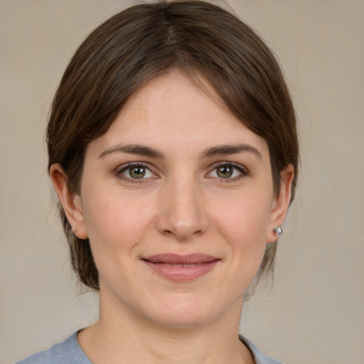 Joyful white young-adult female with medium  brown hair and grey eyes