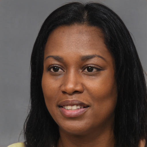 Joyful black young-adult female with long  black hair and brown eyes