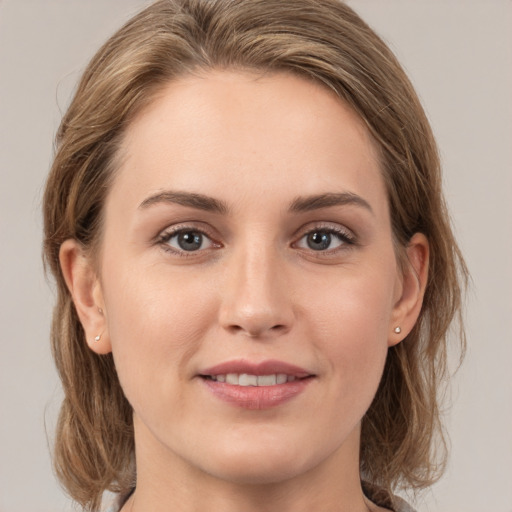 Joyful white young-adult female with medium  brown hair and grey eyes