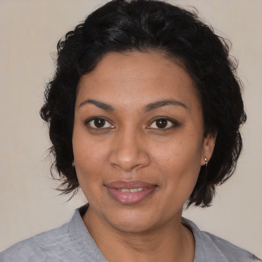 Joyful latino adult female with medium  black hair and brown eyes