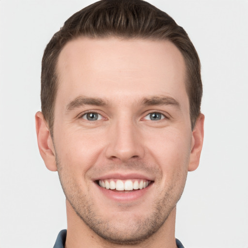 Joyful white young-adult male with short  brown hair and grey eyes